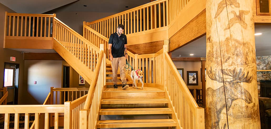 A dog and its owner walking down the Snow Cap Inn stairs.