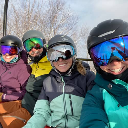 Friends on chairlift smiling