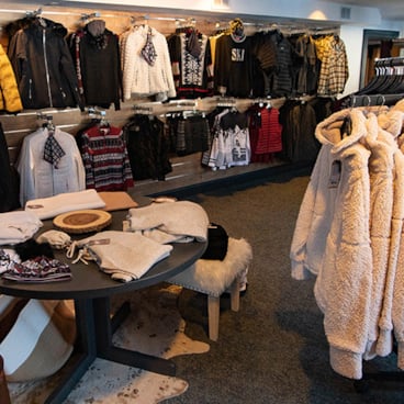 clothing hanging on racks inside ski shop